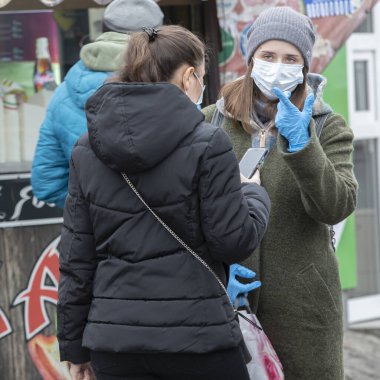 Ukrayna Kiev, 23 Mart 2020, Kyiv 'deki karantina önlemleri. Koronavirüs SARS-CoV-2 veya COVID-19 'dan korunmak için tıbbi maske takan Kiev sokaklarındaki genç kızlar..