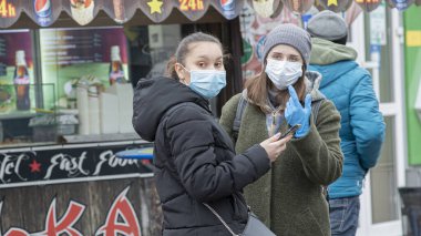 Ukrayna Kiev, 23 Mart 2020, Kyiv 'deki karantina önlemleri. Koronavirüs SARS-CoV-2 veya COVID-19 'dan korunmak için tıbbi maske takan Kiev sokaklarındaki genç kızlar..