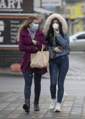 Ukrayna Kiev, 23 Mart 2020, Kyiv 'deki karantina önlemleri. Koronavirüs SARS-CoV-2 veya COVID-19 'dan korunmak için tıbbi maske takan Kiev sokaklarındaki genç kızlar..