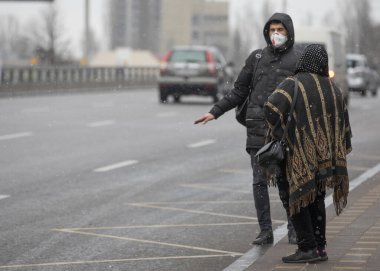 Ukrayna Kiev 23 Mart: SARS-CoV-2 veya COVID-19 koronavirüslerinin yayılmasına karşı karantina tedbirleri. İnsanlar tıbbi maskelerle yürümeye ve iki metreden fazla mesafeyi korumaya zorlanıyorlar..