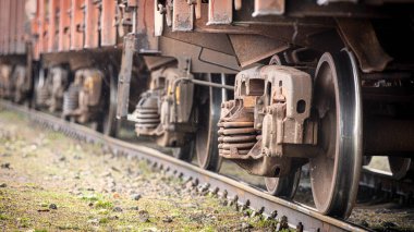 Eski paslı seyyar stoklar, raylarda yük vagonları. Tren tekerleri kapanıyor. Konsept, nakliye.