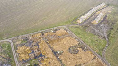 İnsansız hava aracından organik atık deposuna, bir sığır çiftliğine bakın. Gübre, organik gübre viskozitesinin daha fazla kullanılması için özel olarak belirlenmiş alanlarda depolanmıştır..