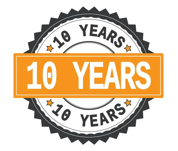 10 YEARS text on grey and orange round stamp, with zig zag borde — Stock Photo, Image