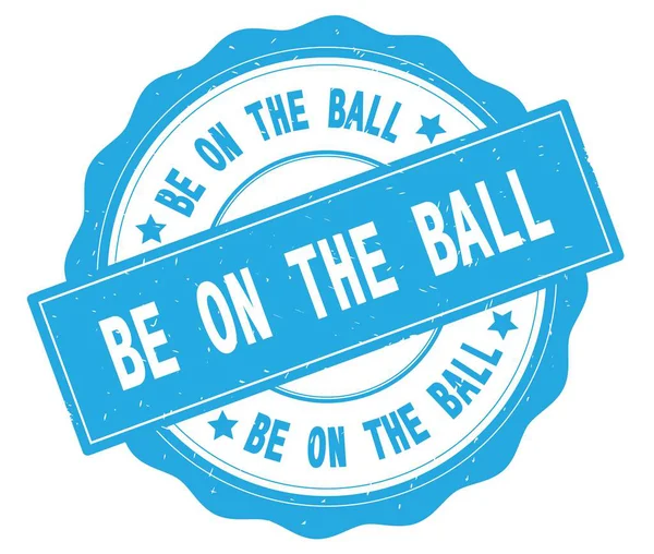 BE ON THE BALL text, written on cyan round badge. — Stock Photo, Image