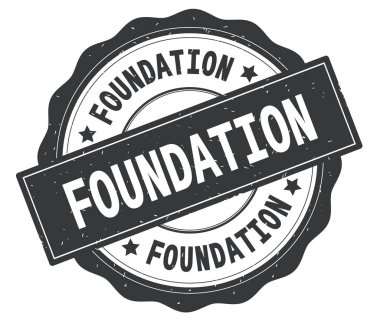 Gri yuvarlak rozet yazılmış Vakfı metni,.