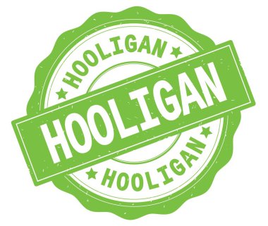 Holigan metin, yeşil yuvarlak rozet yazılmış.