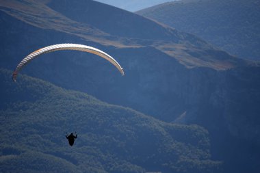 Paraglider dağın üzerinden uçuyor
