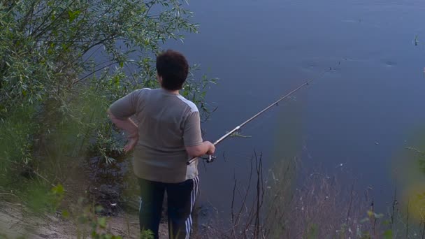 Женщина ловит рыбу на удочке — стоковое видео