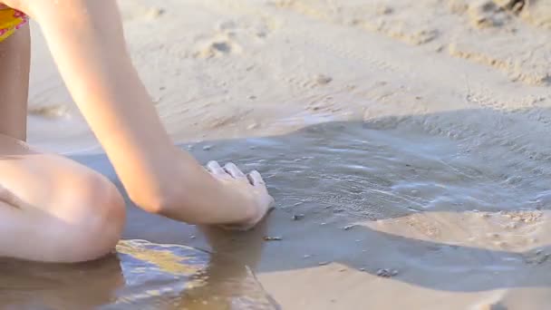 Chica dibuja corazón en arena mojada — Vídeo de stock