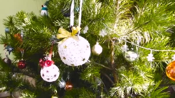 Gran bola blanca en el árbol de Navidad decorado con lazo rojo — Vídeo de stock