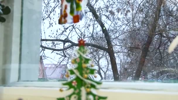 Neva fora, peitoril decorado artesanato árvore de Natal, puxando sobre o vidro é colado boneco de neve — Vídeo de Stock