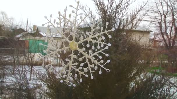 Стеклянное окно, украшенное снежинкой, снег на улице — стоковое видео