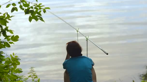 Student dívka rybář loví na břehu řeky, jezera — Stock video