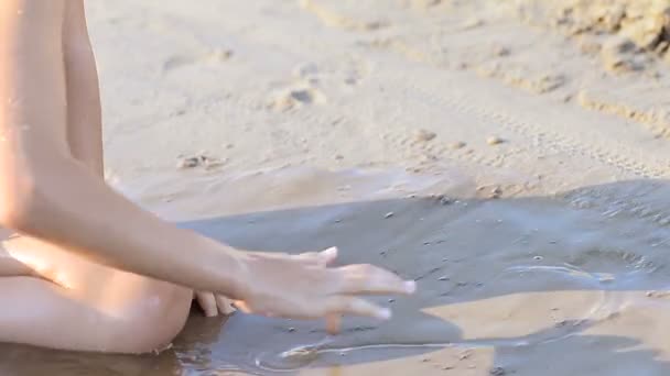 Girl draws heart on wet sand — Stock Video