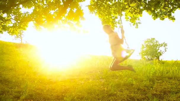 Meisje swingen op schommel in park, in de zon, — Stockvideo