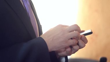 işadamı denetler smartphone e-posta, bir adam bir takım elbise ve kravat cep telefonu haber okuma