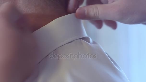 Man straightens the collar on a white shirt — Stock Video