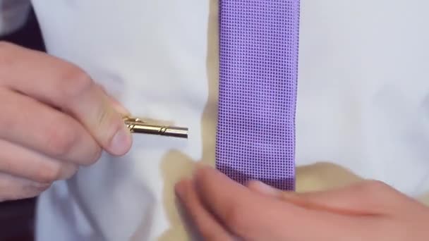 Hombre se pone una corbata azul en una camisa blanca — Vídeos de Stock