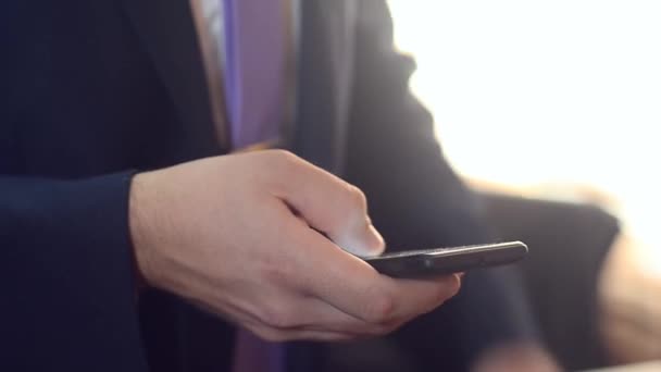 Смартфон бизнесмена, набирающий сообщение, мужчина в костюме и галстуке, держащий в руках мобильный телефон — стоковое видео