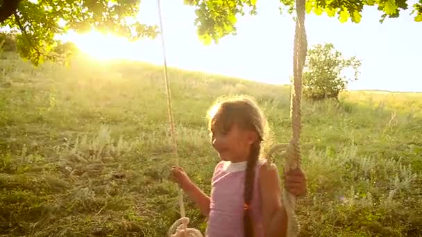 Sun girl swinging on swing in the park, on tree swing — Stock Video