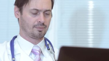 Doktor içinde hareket eden telefon, ofiste çalışan bir doktor bir mektup yazar.