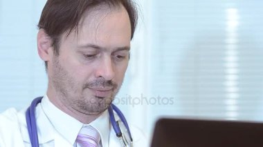 Erkek Doktor, dizüstü bilgisayar ofiste çalışan yakın çekim.