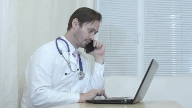 Ofiste telefonda konuşurken doktor.