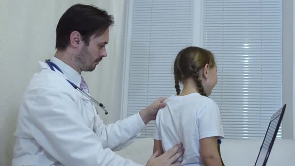 Dokter onderzoekt de childs terug, kinderarts behandeling van een meisje. — Stockvideo