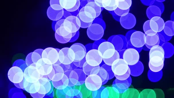 Lumières colorées déconcentrées brillantes, bokeh scintille circulaire bleue, guirlande brillante dans la ville de nuit . — Video