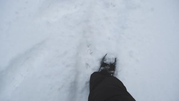 Man van de benen lopen in de sneeuw, de winter weg in het park. — Stockvideo