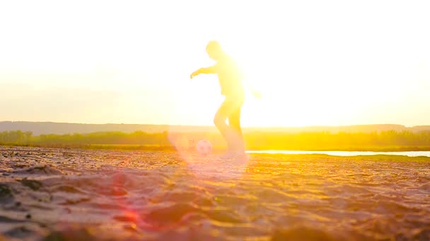 Flickan och mannen som spelar fotboll på stranden i solen. — Stockvideo