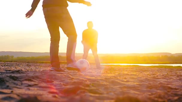 Gry piłka nożna na plaży o zachodzie słońca, sportowe studentów relaks na plaży. — Wideo stockowe