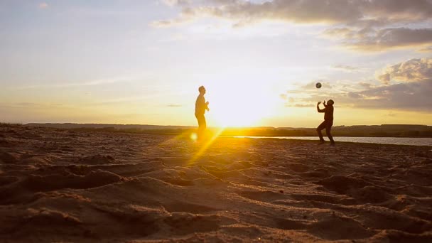 Entrenamiento de hombres en voleibol en la playa en el sol, voleibol de playa en la arena en la noche de verano . — Vídeo de stock