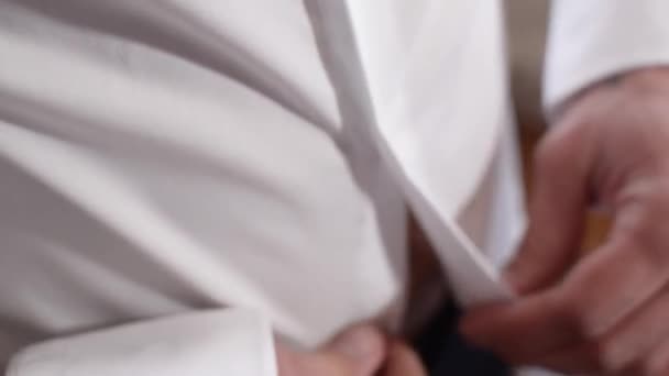 Homme met une chemise blanche, un homme attache des boutons sur une chemise blanche . — Video