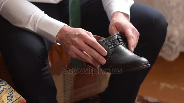 Hombre en camisa blanca y pantalones oscuros, sosteniendo un zapatos negros, hombre lleva zapatos de cuero negro . — Vídeos de Stock