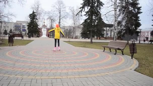 Девушка на роликовых коньках в весеннем парке — стоковое видео