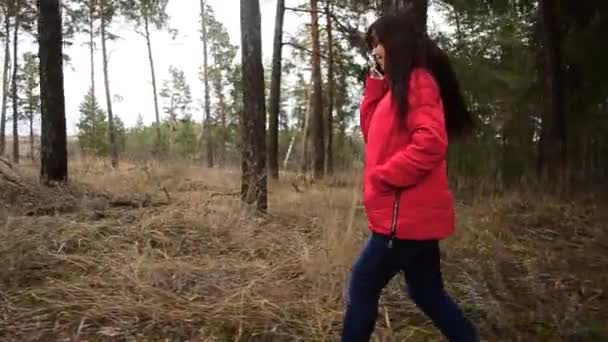 Muchacha joven con el pelo largo y hermoso caminando en el parque en primavera — Vídeos de Stock