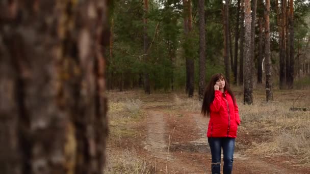 Zwanger meisje praten over telefoon in Park voorjaarsbijeenkomst — Stockvideo