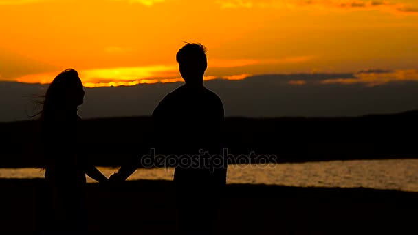 Amorosas siluetas de hombre y mujer, caminando al atardecer — Vídeos de Stock