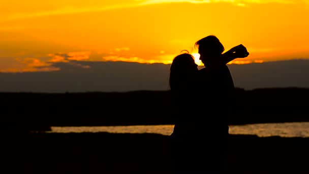 Aşık kız ve plaj gün batımında kucaklayan üzerinde adam — Stok video