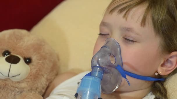 Chica es tratada con inhalación, niño abrazando su juguete favorito . — Vídeos de Stock