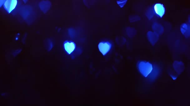 Lampu berwarna-warni dalam bentuk hati bersinar dalam gelap, romantis bokeh biru muda lampu merah dalam gelap . — Stok Video