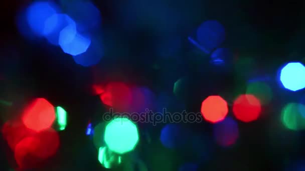 Luces de color desenfocadas que brillan azul rojo verde claro en luces intermitentes circulares oscuras y multicolores sobre un fondo oscuro — Vídeos de Stock