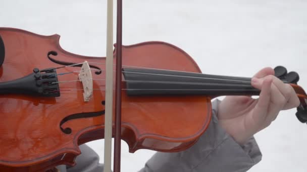 Child plays the violin in winter, close up — Stock Video