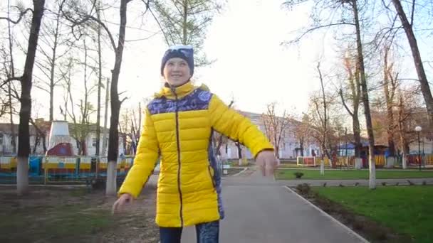 Mooi meisje leert schaatsen op rolschaatsen in stad Park in het voorjaar — Stockvideo