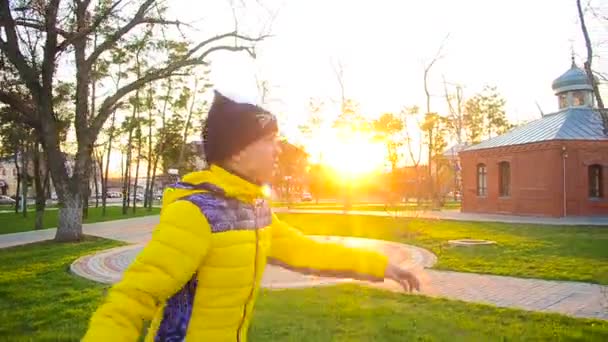 Молода дівчина катається на роликових ковзанах у весняному парку на заході сонця . — стокове відео