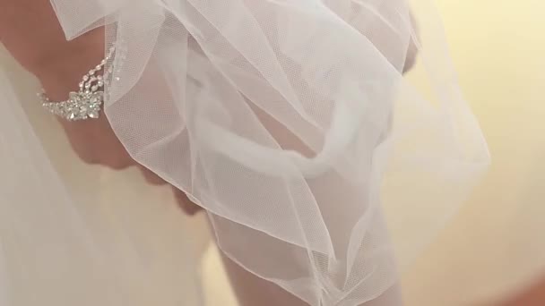 Невеста в белом платье надевает ноги, белые чулки, крупным планом — стоковое видео