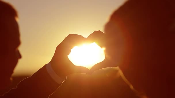 日没の手で恋人を示す心 — ストック動画