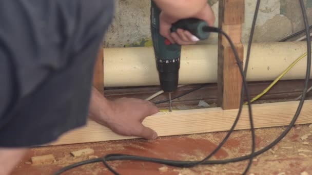Electric drill drills wooden bar, close up, repairs in house — Stock Video