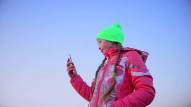 telefon, mavi gökyüzü karşı genç kız fotoğrafı.